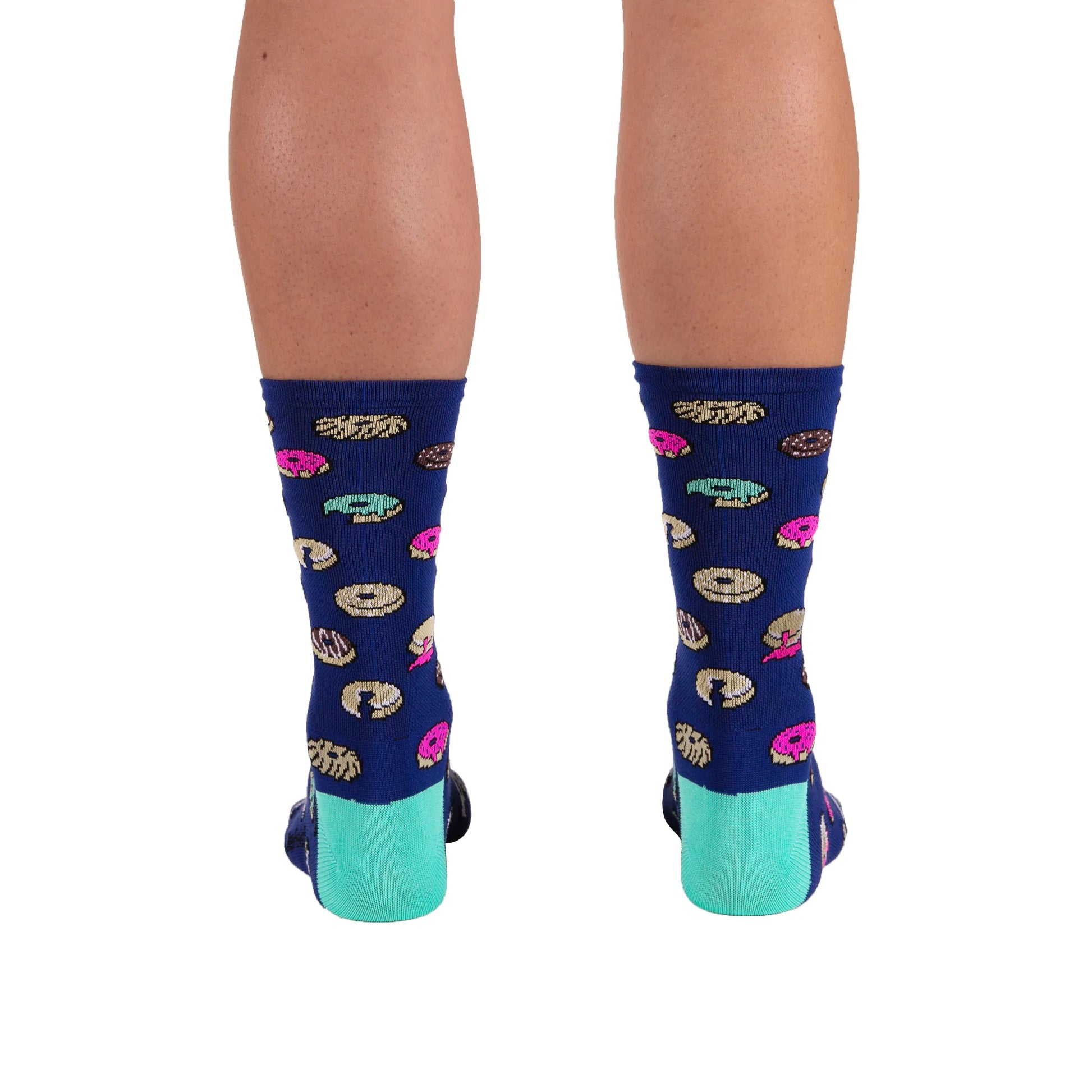The back of a pair of legs wearing DeFeet Aireator 6” Doughnut cycling sock in light navy with doughnuts on cuff and celeste green heel and toe.
